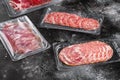Vacuum packed sausage Prosciutto salami, on black dark stone table background Royalty Free Stock Photo