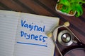 Vaginal Dryness write on a book isolated on Wooden Table