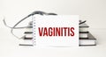 Vaginitis word on notepad and stethoscope on white background