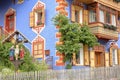 The colorful facade of a traditional house in Ortisei with a sculpture of Jesus Christ in the foreground