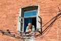 VALAAM, RUSSIA - Aug 15 2015, View of an old man looking out from a window of a brick building, on Aug 15 2015 in VALAAM, RUSSIA Royalty Free Stock Photo