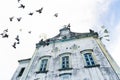 Several pigeons flying in front of the Matriz church in the city of Valenca, Bahia