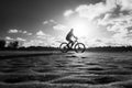 A cyclist walking, in the late afternoon, on the sands of Guaibim beach in Valenca, Bahia