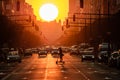 Valencia port avenue, giant sun during sunset, silhouette of man on electric scooter and cars