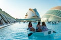 Valencia, Spain - 10 august 2019: people enjoy a boat ride inside the pool of city of arts and sciences in valencia at sunset with