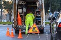 Valencia, Spain - January 16, 2019: Worker inside his van, loaded with tools, protected from traffic with cones while repairing a