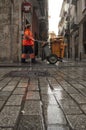 Street cleaning worker with wet floor