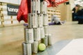 Valencia, Spain - March 31, 2019: Children playing to knock down a wall made with tin cans with balls