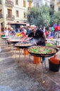 Valencia, Spain, March 2024: Group of people cooking communal paellas on the street during the Fallas festivities in