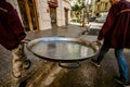 Valencia, Spain - March 19, 2019: Two chefs transport a huge paella pan to prepare the traditional Valencian rice