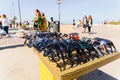 Valencia, Spain - May 12, 2019: Illegal immigrants selling false glasses and souvenirs to tourists on the beach of Valencia