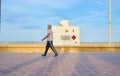 Valencia, Spain; 05/25/2020. People with masks strolling along the Valencia promenade, in front of the red cross lifeguard station Royalty Free Stock Photo