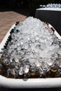 Valencia, Spain - September 28, 2021: Bottles of beers and soft drinks inside a barrel with ice to cool it down