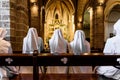 Valencia, Spain - September 25, 2019: Group of Christian nuns with white robes praying in a church