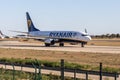 Valencia, Spain - 04 04 2023: White and blue plane with chassis is taxiing on the landscape background