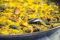 Paella chicken and rabbit dish in its pot served on the table with white tablecloth Royalty Free Stock Photo
