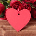 Valentine background of gift tag and red roses on wood Royalty Free Stock Photo