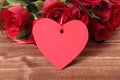 Valentine background of gift tag and red roses on wood Royalty Free Stock Photo