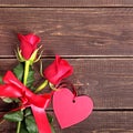 Valentine background of gift tag and red roses on wood Royalty Free Stock Photo