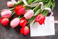 Valentine background or greeting card. Congratulatory sheet of paper with red and ÃÂ¿ÃÂ¸ÃÂ½ÃÂº tulips on a dark stone background.