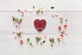 Valentine background with handmade heart shape paper card in pink rose flowers circle on white rustic wood Royalty Free Stock Photo