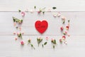 Valentine background with handmade heart shape paper card pink in rose flowers circle on white rustic wood Royalty Free Stock Photo