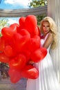 Valentine Beautiful girl with red balloons laugh, in the park. Beautiful happy young woman.