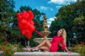 Valentine Beautiful girl with red balloons laugh, in the park. Beautiful happy young woman. Birthday party.