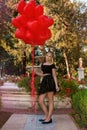 Valentine Beautiful young girl with red balloons laugh, in the park. Beautiful happy kid. Christmas party. Joyful little model