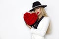 Valentine Beauty, elegant girl with red heart with roses. Portrait of a young female model with gift and hat. Royalty Free Stock Photo