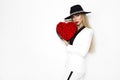 Valentine Beauty, elegant girl with red heart with roses. Portrait of a young female model with gift and hat. Royalty Free Stock Photo