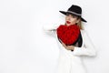 Valentine Beauty, elegant girl with red heart with roses. Portrait of a young female model with gift and hat. Royalty Free Stock Photo
