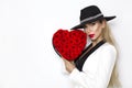 Valentine Beauty, elegant girl with red heart with roses. Portrait of a young female model with gift and hat. Royalty Free Stock Photo