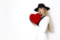 Valentine Beauty, elegant girl with red heart with roses. Portrait of a young female model with gift and hat. Royalty Free Stock Photo