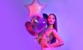 Valentine Beauty girl air balloons laughing in neon lights, on ultra violet background. Beautiful Happy Young woman, holiday party Royalty Free Stock Photo