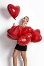Valentine Beauty girl with red air balloon portrait pointing hand, isolated on background. Royalty Free Stock Photo