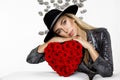 Valentine Beauty girl with red heart roses. Portrait of a young female model with gift and hat, isolated on background.