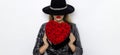 Valentine Beauty girl with red heart roses. Portrait of a young female model with gift and hat, isolated on background. Royalty Free Stock Photo