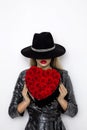 Valentine Beauty girl with red heart roses. Portrait of a young female model with gift and hat, isolated on background. Royalty Free Stock Photo