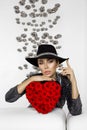 Valentine Beauty girl with red heart roses. Portrait of a young female model with gift and hat, isolated on background. Royalty Free Stock Photo