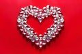 Valentine card made of shining diamonds in shape of heart on red background. Precious stones on red