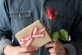 Valentine concept, Man hand holding red rose and gift box Royalty Free Stock Photo