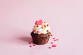Valentine cupcake, decorated with sweet hearts on pink pastel background