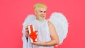 Valentine Cupid with gift. Angel with present. Valentines day. Smiling man with white wings. Royalty Free Stock Photo