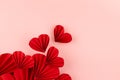 Valentine day background with flow of flying red paper ribbed hearts on soft light pink background as festive backdrop, top view. Royalty Free Stock Photo