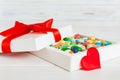 Valentine day composition: sweet candy, with gift boxes with bow and red felt hearts, photo template, background