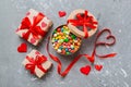 Valentine day composition: sweet candy, with gift boxes with bow and red felt hearts, photo template, background. Top