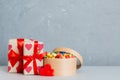 Valentine day composition: sweet candy, with gift boxes with bow and red felt hearts, photo template, background