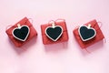 Valentine day composition: three red gift boxes with clothespin as heart with space for text on chalkboard on pastel pink backgrou Royalty Free Stock Photo
