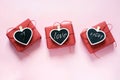 Valentine day composition: three red gift boxes with clothespin as heart with text on chalkboard on pastel pink background. View f Royalty Free Stock Photo